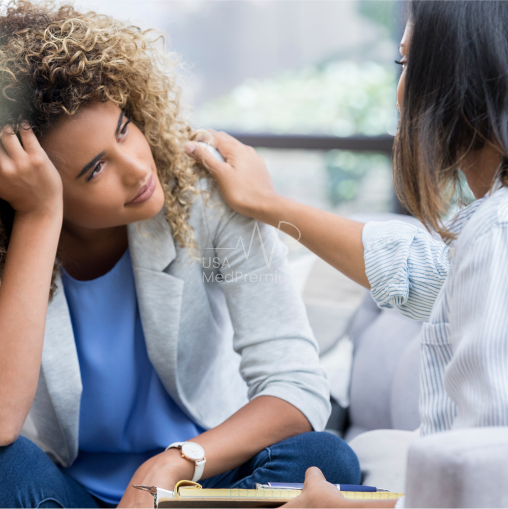 Therapist taking notes during a one-on-one counseling session with a client in a calm, warmly lit therapy room